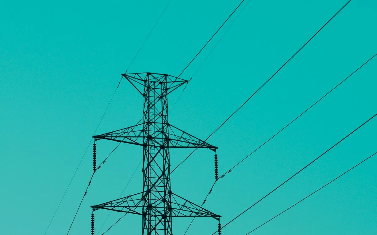 Electric transmission tower against a blue sky