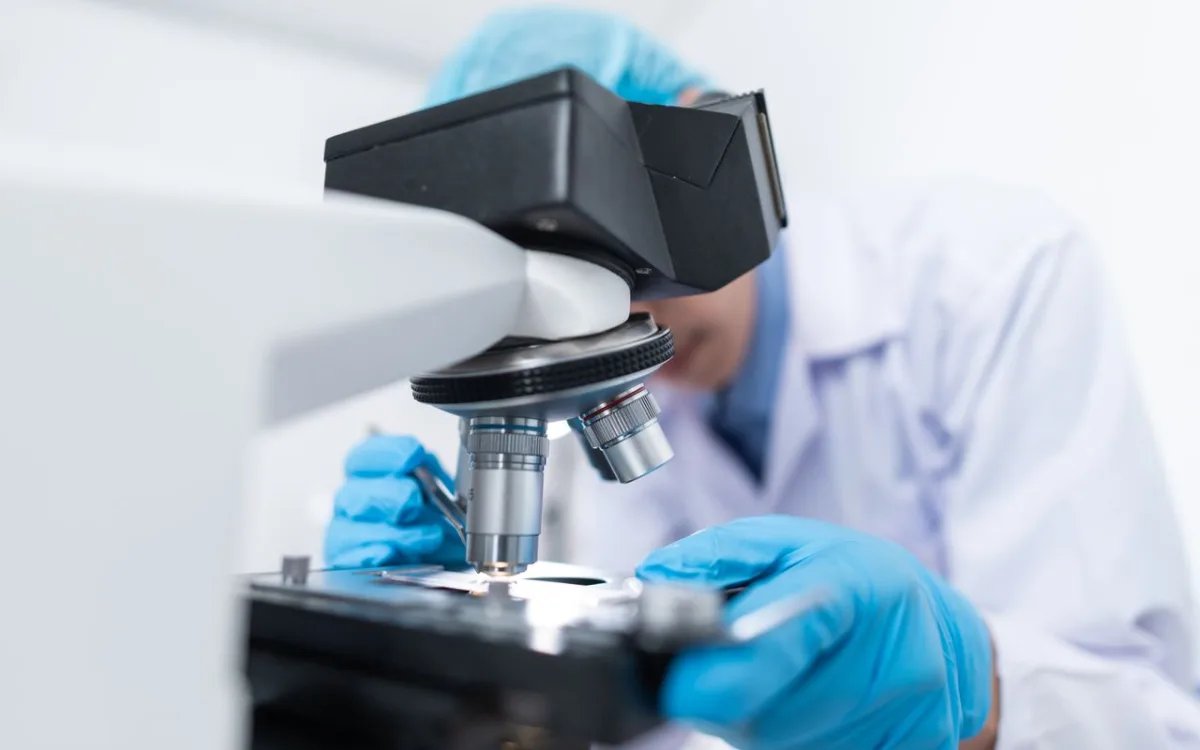 Scientist examining samples under a microscope in a modern laboratory