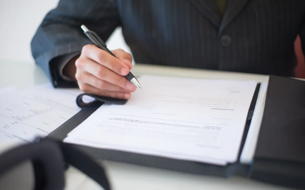 Hand signing an insurance policy document